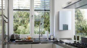 Scaldabagno Vaillant montato a parete in una cucina moderna con vista su un giardino, progettato per efficienza e design compatto.