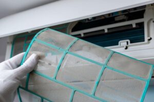 confronto tra filtri del condizionatore prima e dopo la pulizia, con polvere visibile